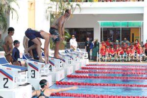 Students and staff participate in a swimming event at the Australian International School Malaysia pool reopening celebration.