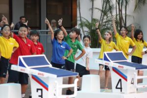 Students from different school houses performing during the Australian International School Malaysia pool reopening event.